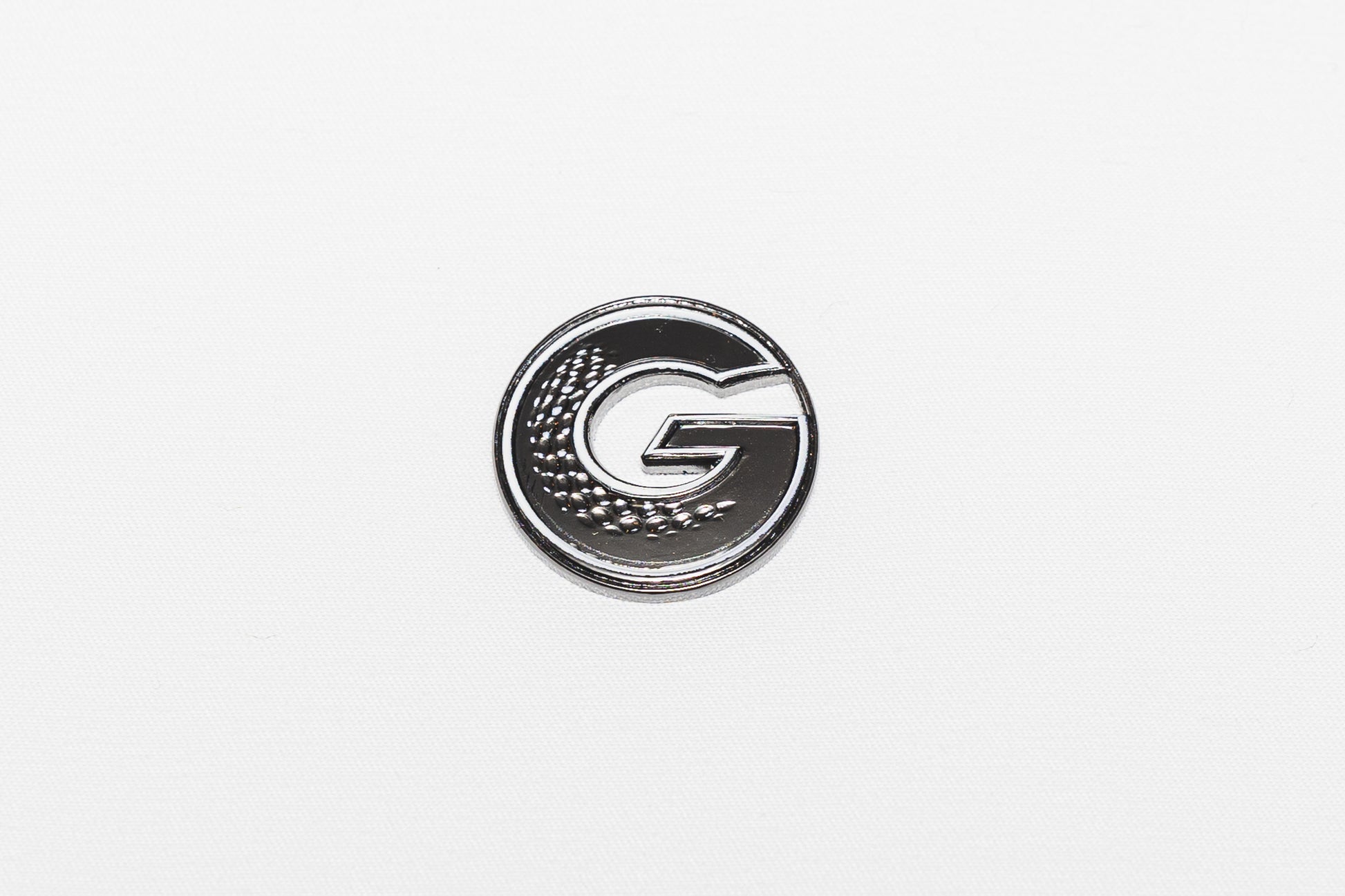 G•MARK Black with White Trim magnetic golf ball marker, angle view